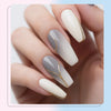 A hand displays five almond-shaped nails with a soft gray and white gradient manicure featuring thin gold line art details.