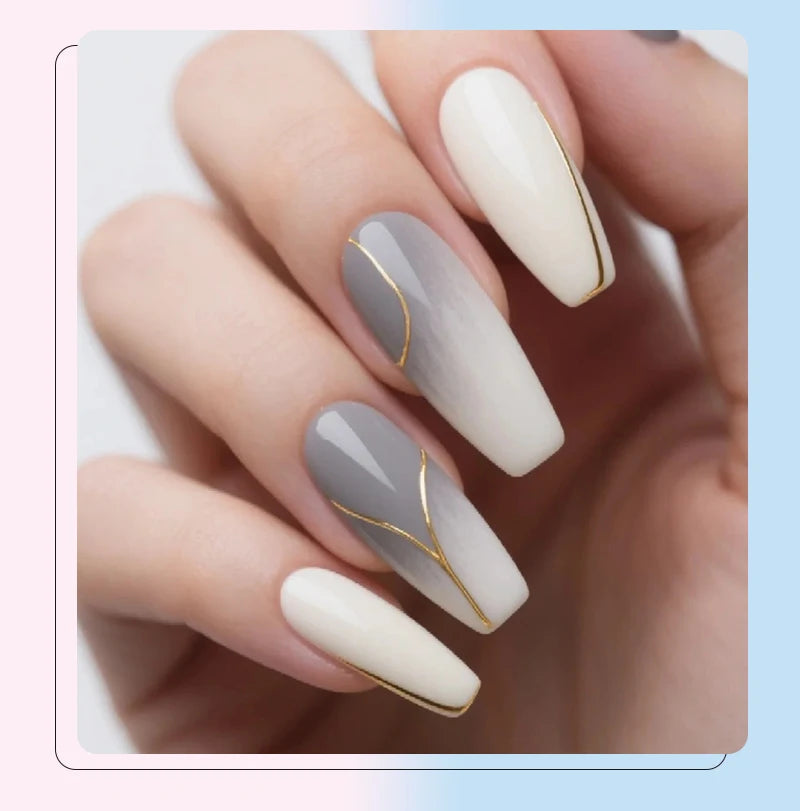 A hand displays five almond-shaped nails with a soft gray and white gradient manicure featuring thin gold line art details.