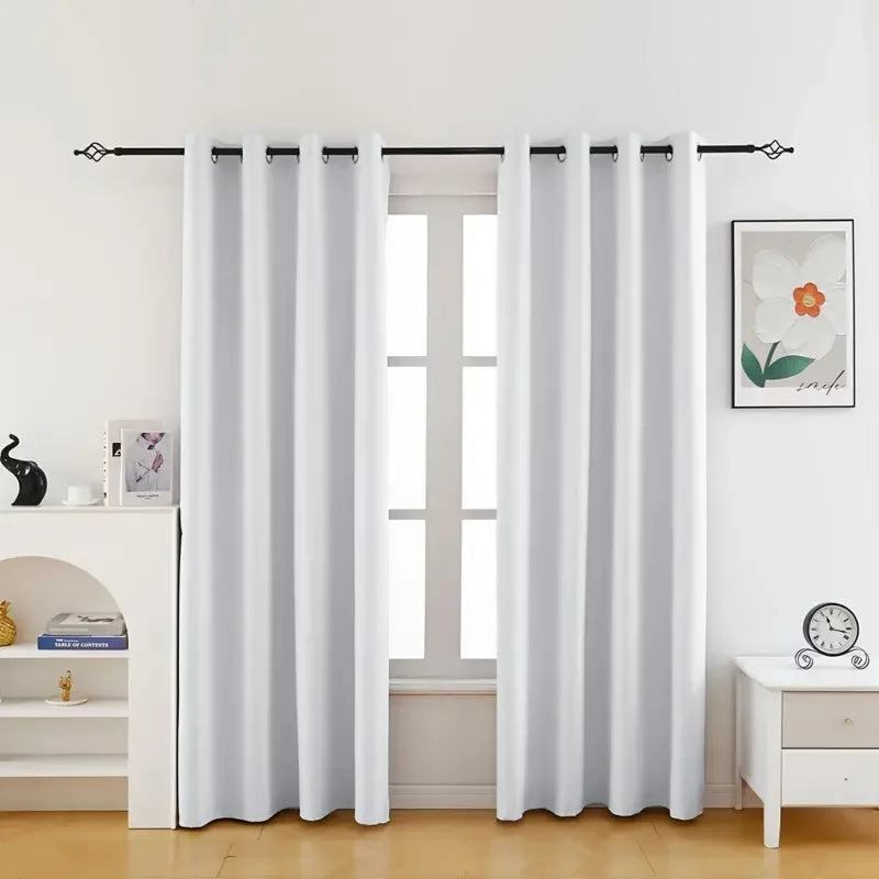 White floral blackout curtain panels hanging in a window frame.