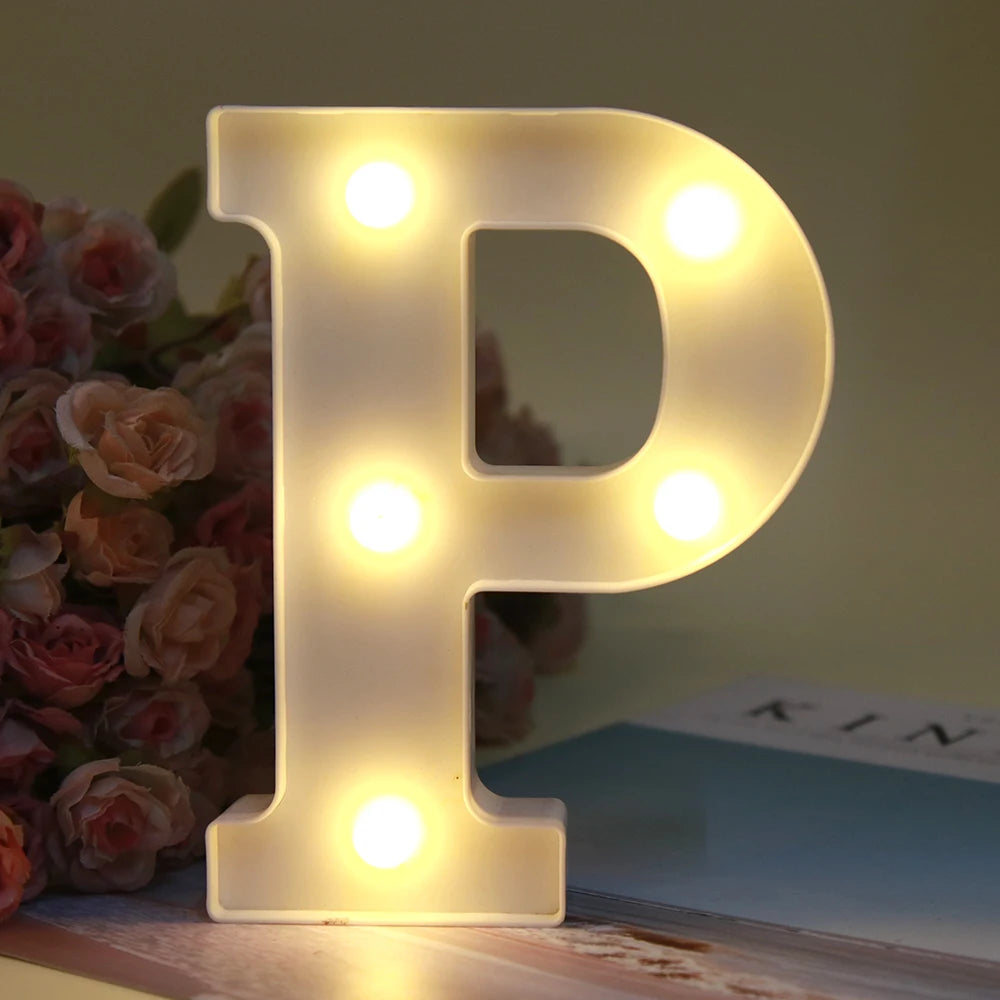 Lumière de nuit en forme de lettre P, alphabet blanc LED lumineux, posée sur une surface en bois.