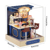 A wooden miniature Japanese sakura tea house display featuring a cake and milk tea setup.