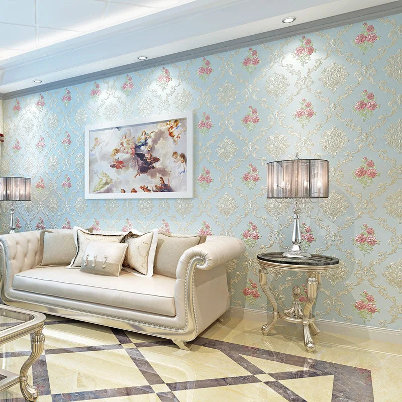 Elegant light blue floral wallpaper covering a wall with a cream sofa and decorative table.