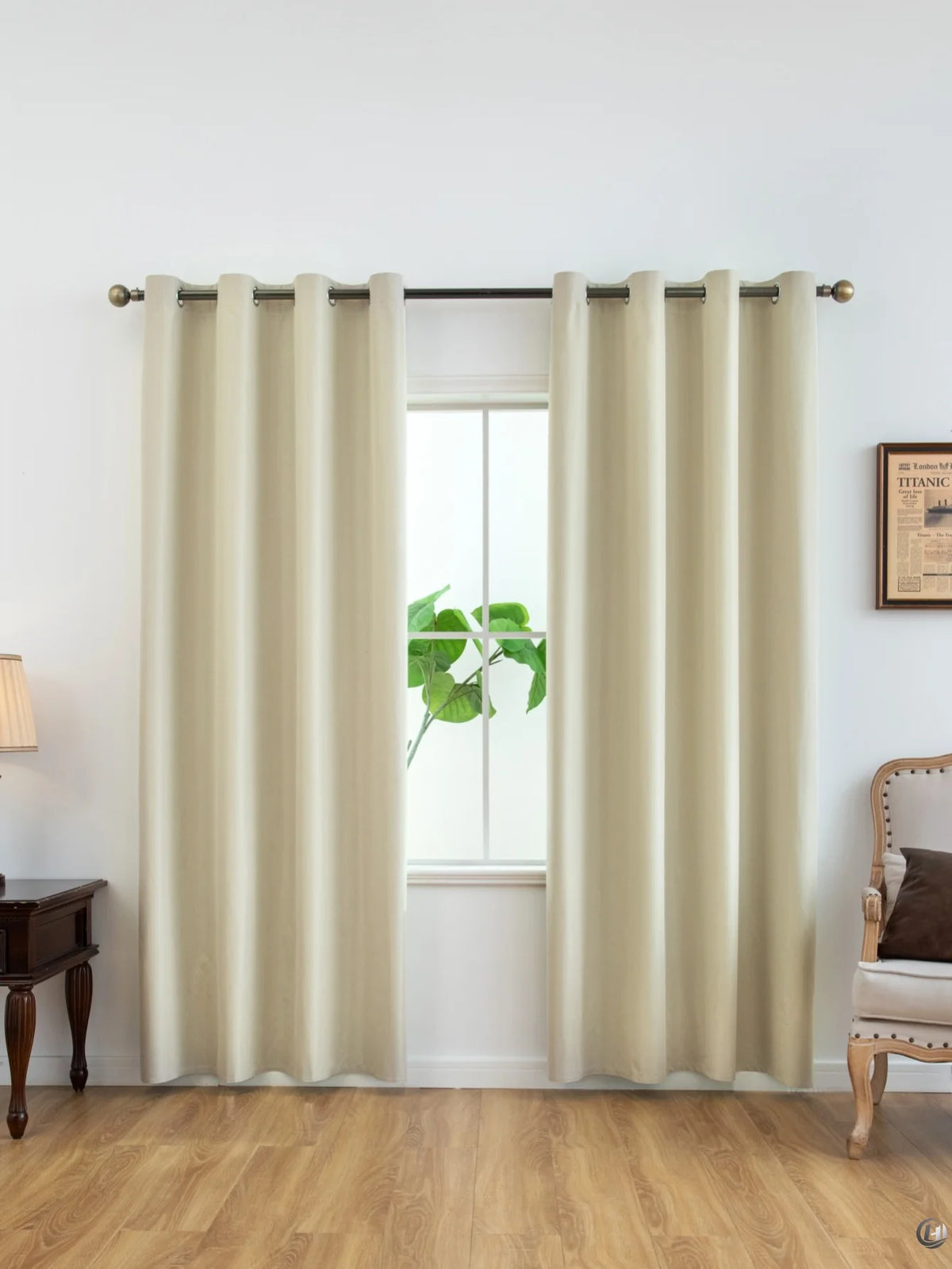 Cremefarbene Verdunklungsvorhänge, die in einem Fenster hängen, mit einer grünen Pflanze sichtbar.