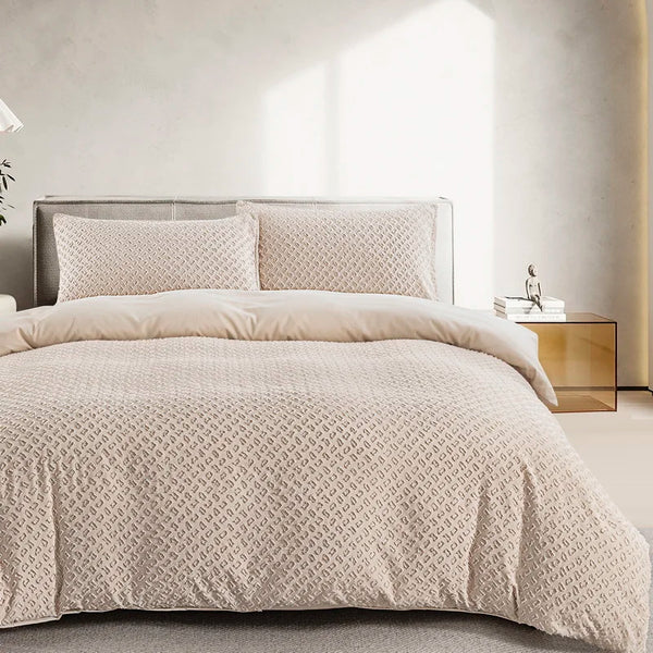 A beige tufted duvet cover set with a matching pillow on a bed in a bright room.