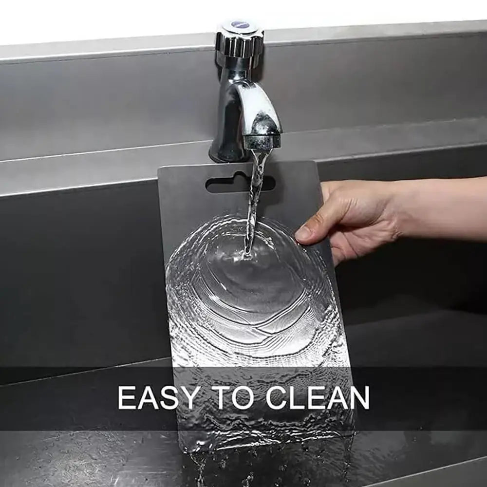 A stainless steel faucet is shown pouring water onto a double-sided cutting board for easy cleaning.
