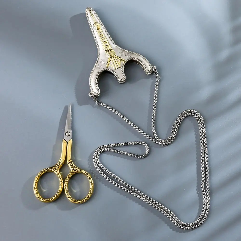 Vintage stainless steel sewing scissors with a chain attached