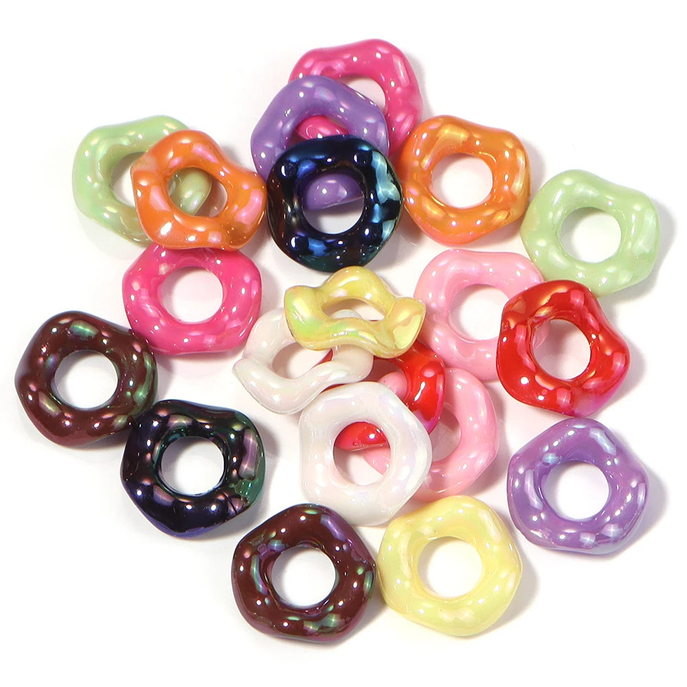 A collection of colorful acrylic spacer beads shaped like waves in various shades including pink, purple, green, and orange.