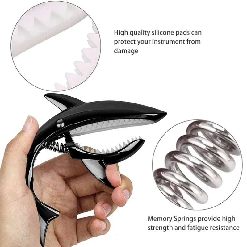 A black shark-design guitar capo with zinc alloy build and memory springs for high strength