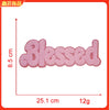 Pink embroidered patch with the word Blessed on a white background