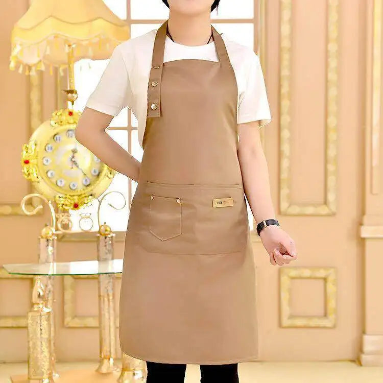 A person wearing a beige cotton apron in a light-colored shirt standing in a well-lit room.