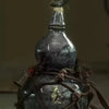 A dark ceramic gourd wine set with a stopper and net bag tied with twine.
