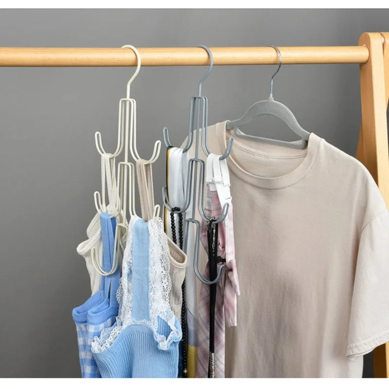 A wooden clothing rack with a multi-layered hanging organizer displaying various hats, bags, and scarves.