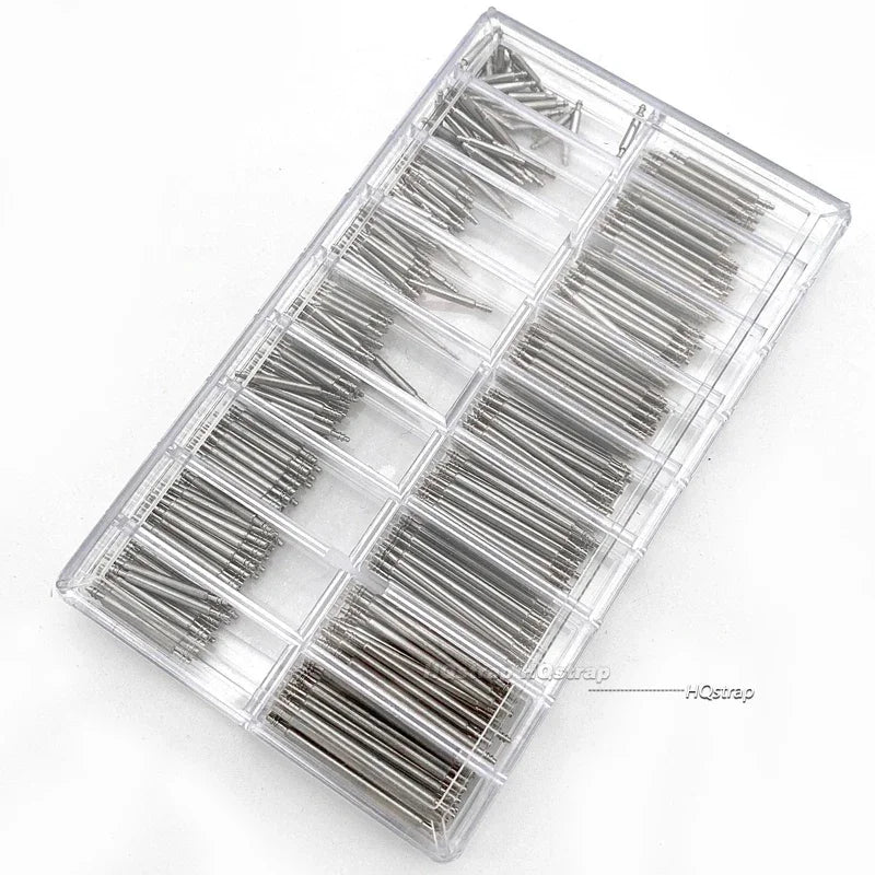 A clear plastic tray containing an assortment of stainless steel watch spring bars.