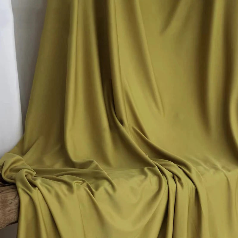Flowing olive green stretch jersey fabric draped in soft folds for decor