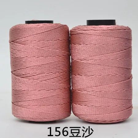 Two spools of pink 3-ply polyester knitting yarn for crochet and hand crafts