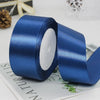 A roll of deep blue satin ribbon used for gift wrapping or DIY crafts.