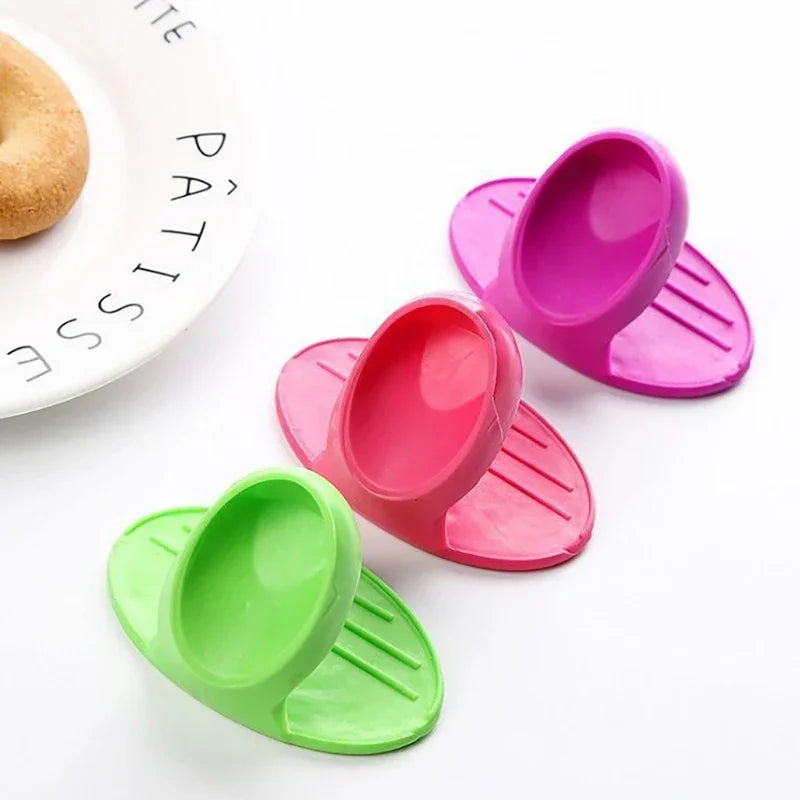 A set of heat-resistant silicone finger covers in various shades of pink and green for baking and cooking.
