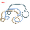 Three silicone pacifier clips or teethers in various shades of blue and beige