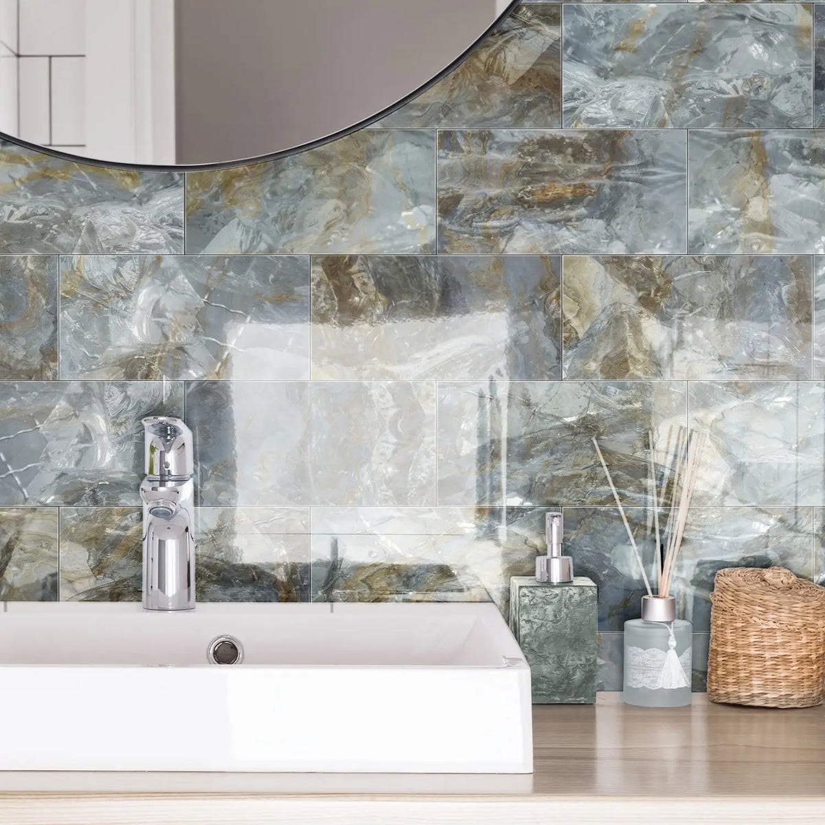 A bathroom wall featuring marble self-adhesive tiles with gray and gold veining behind a white sink.