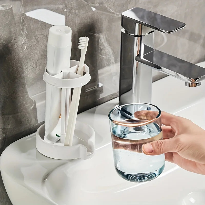 Una mano sostiene un vaso de agua cerca de un organizador para cepillo y pasta de dientes en un lavabo de baño montado en la 