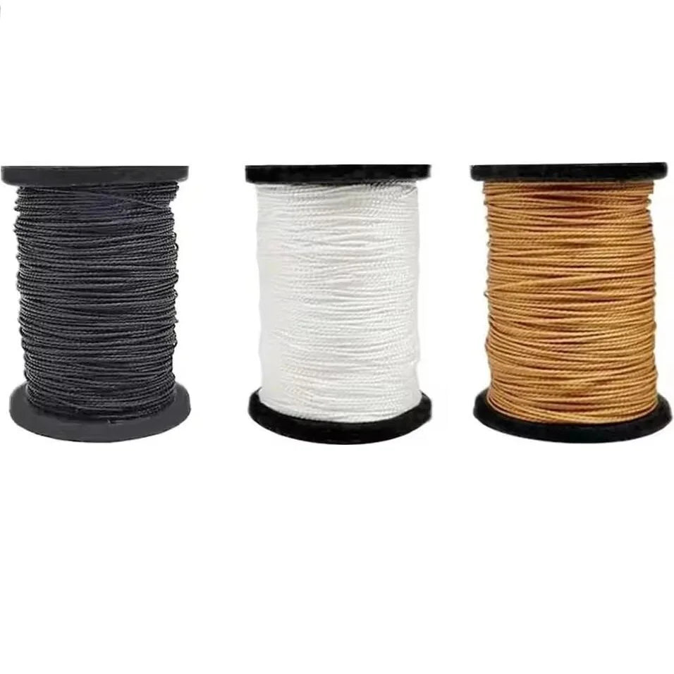 Three spools of waxed thread in black, white, and tan for a professional leather sewing kit
