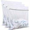 Three white reusable mesh laundry bags with gray zippers stacked together