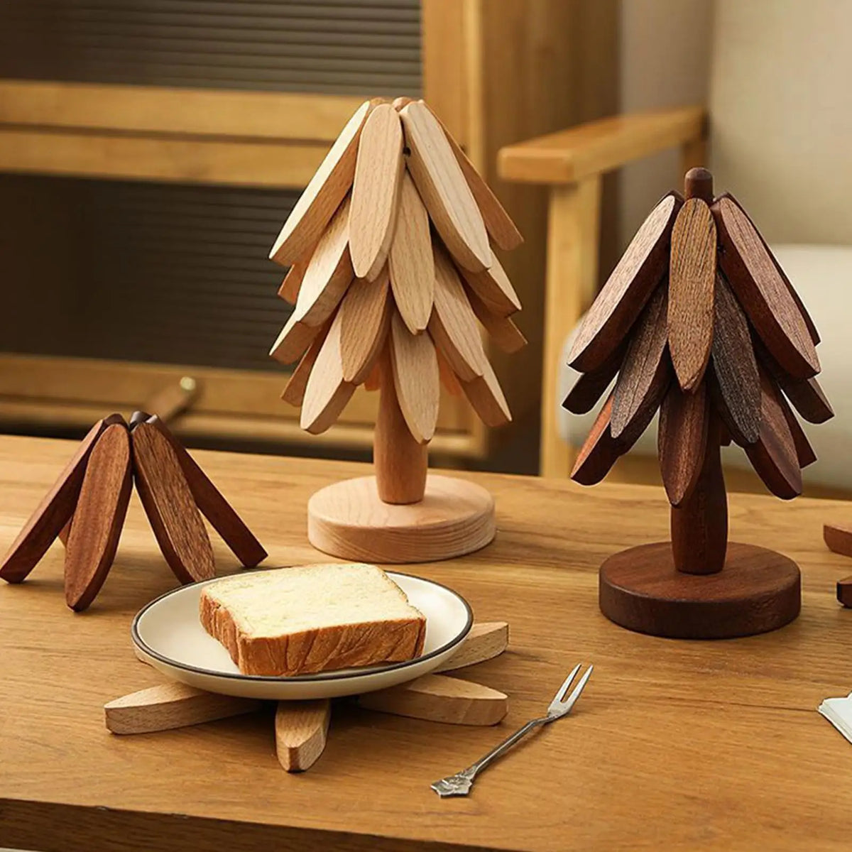 Ein Set faltbarer Holz-Untersetzer in Form eines Kieferbaumes auf einem Holztisch.