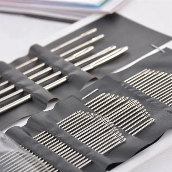 A dark gray silicone pouch filled with a set of stainless steel big eye sewing needles.