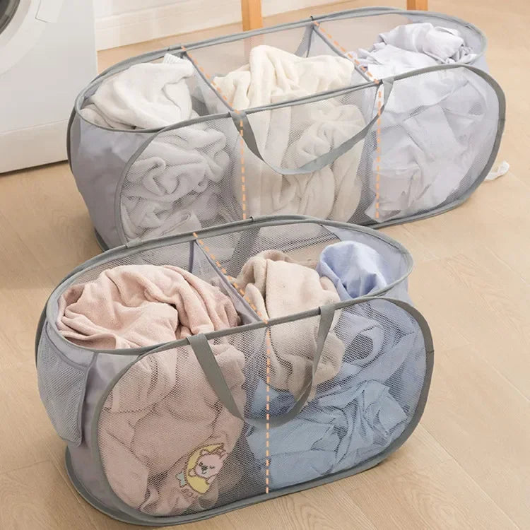 A gray folding mesh laundry basket filled with folded white and light-colored clothing.