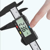 A hand is holding a digital caliper with a black body and LCD display, showing a measurement scale.