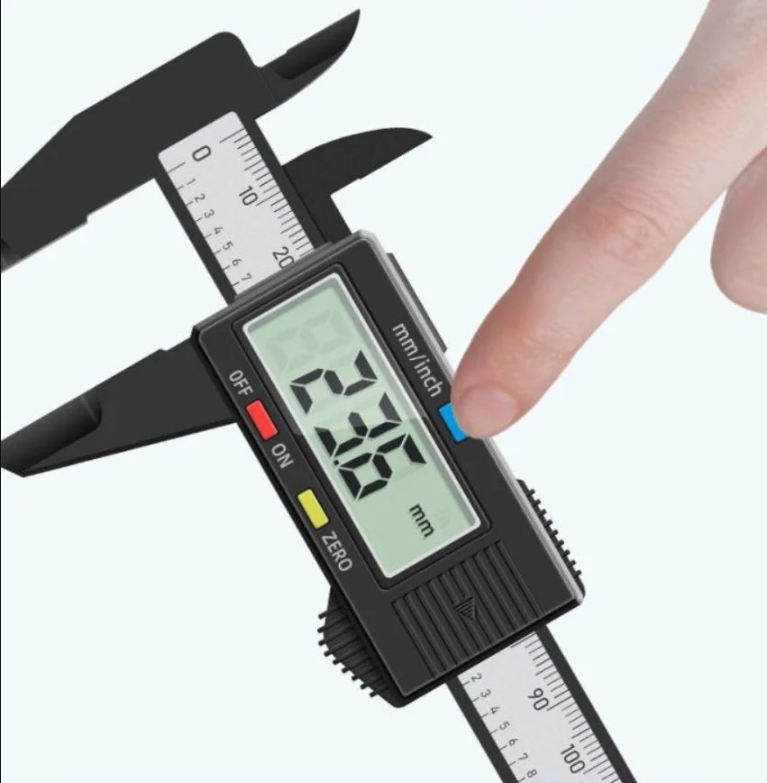 A hand is holding a digital caliper with a black body and LCD display, showing a measurement scale.