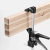 A black heavy-duty furniture installation lifting bracket with a metal ruler attached to a wooden plank.