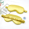 Golden silk sleep mask with ruffled edges shown next to a box labeled Chanel