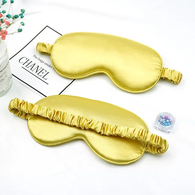 Golden silk sleep mask with ruffled edges shown next to a box labeled Chanel