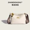 A cream-colored PU leather crossbody shoulder bag with gold hardware and a patterned strap.