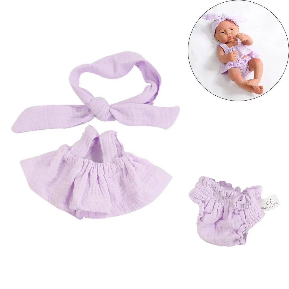A lavender 3-piece doll outfit set featuring a bow, a ruffled top, and matching bottoms for a baby doll.