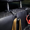 Close-up of a black car seat storage hook set with crystal diamond accents and tan leather strap.