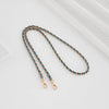 A delicate chain shoulder strap buckle in gold-toned metal and turquoise beads is displayed on a white background.