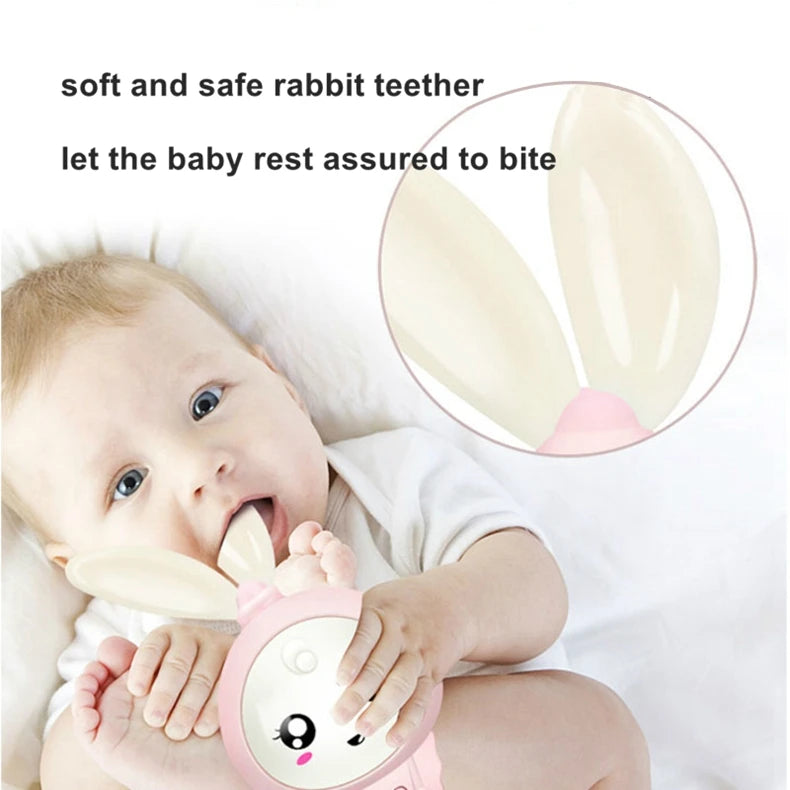 A baby is holding a pink rabbit teether toy while resting on a white surface.