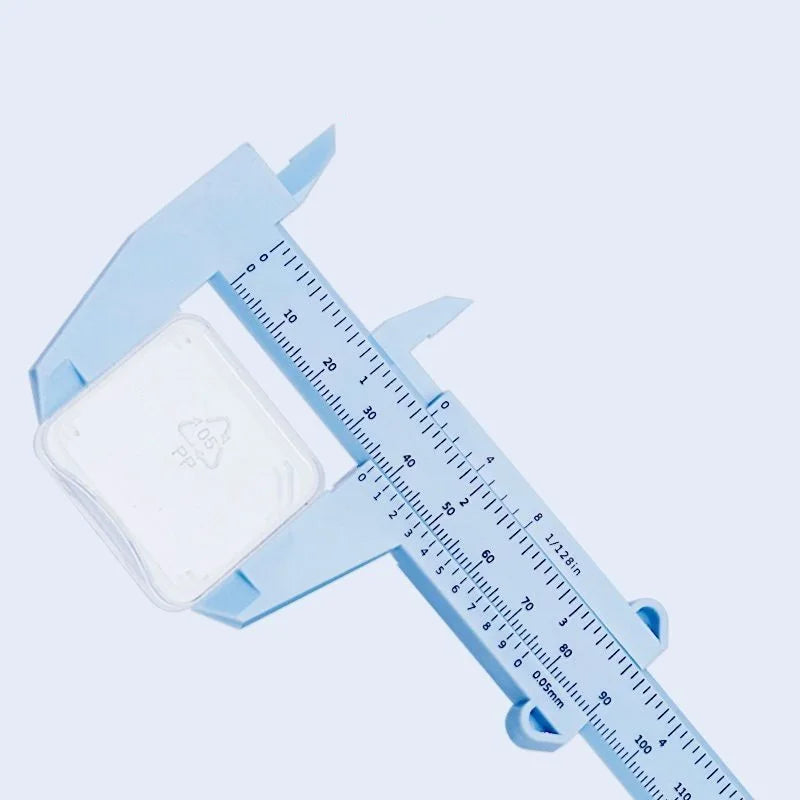 Light blue plastic vernier caliper tool with a white measuring block and scale markings.