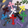 A collection of ten vibrant embroidered cross patches in various colors including black, pink, white, yellow, green, and purp