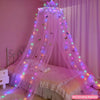 A pink sheer dome mosquito net with LED lights draped over a bed for a whimsical atmosphere.