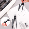 A hand holds a black geometry drafting set including a compass, ruler, and pens on a white paper.