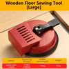 A large red wooden floor sewing tool with a suction cup is shown on a light wood surface.