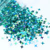 A pile of iridescent teal and green holographic star sequins for resin crafts.