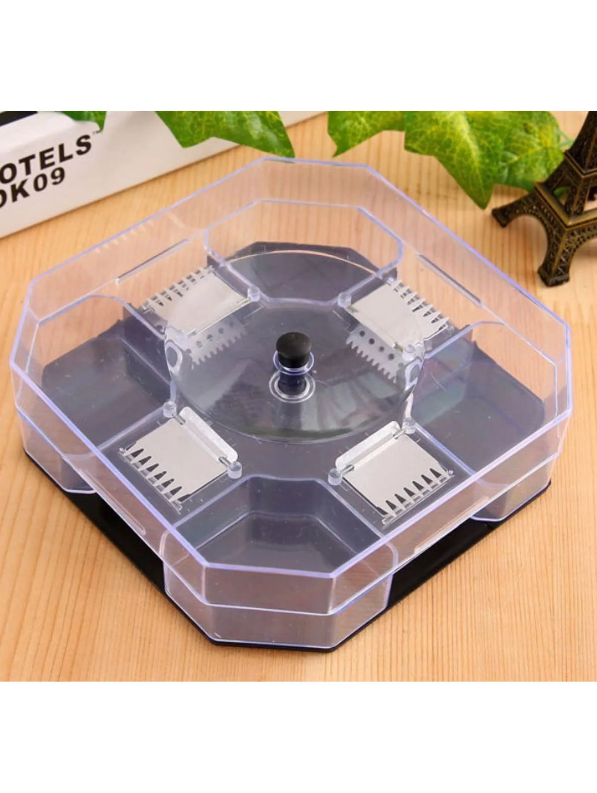 Clear plastic hexagonal trap for cockroaches with three bait packs on a wooden surface.