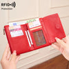A red RFID-blocking tri-fold wallet with a zipper pocket is shown being held by a hand.