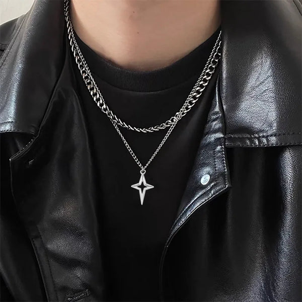 Rapproché d'un collier en étoile cubaine de titane porté autour du cou, superposé à une autre chaîne.