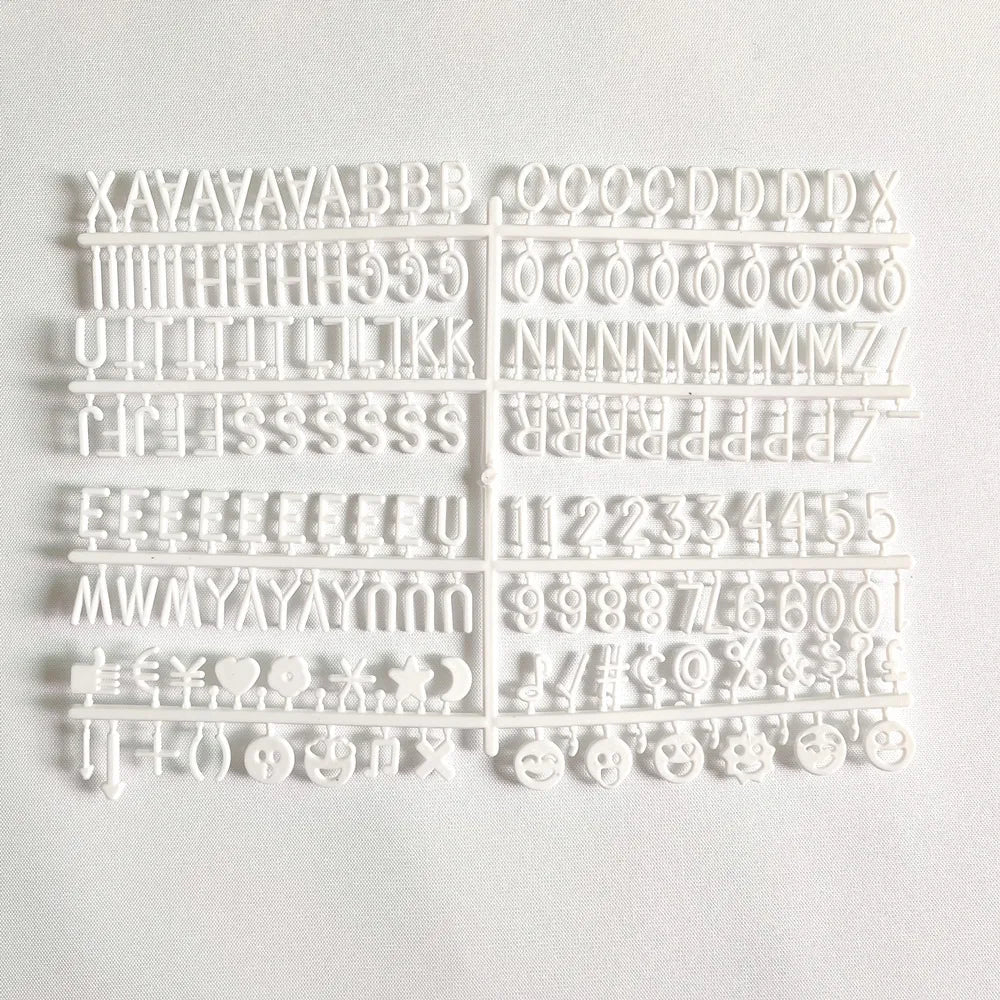 Tablero de fieltro blanco con marco de madera mostrando varias letras y símbolos.
