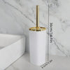 A tall white toilet brush set with a gold rotating stand displayed on a marble surface.